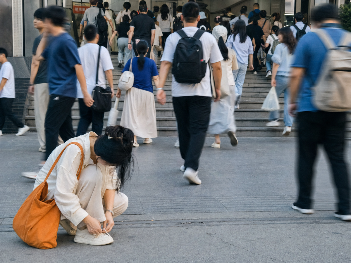 早高峰人流中停下来系好鞋带