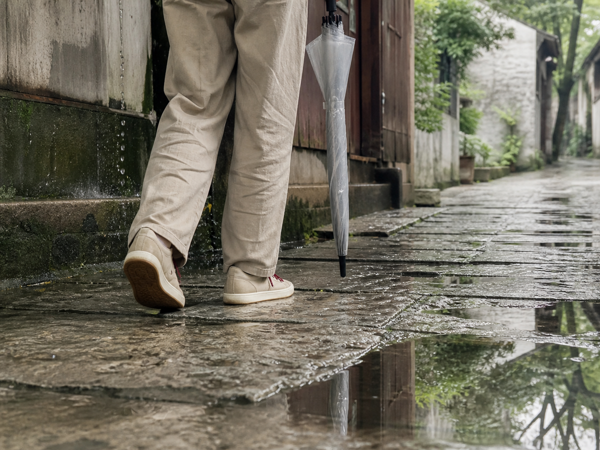 雨后撑着收起的伞稳稳走过石板路